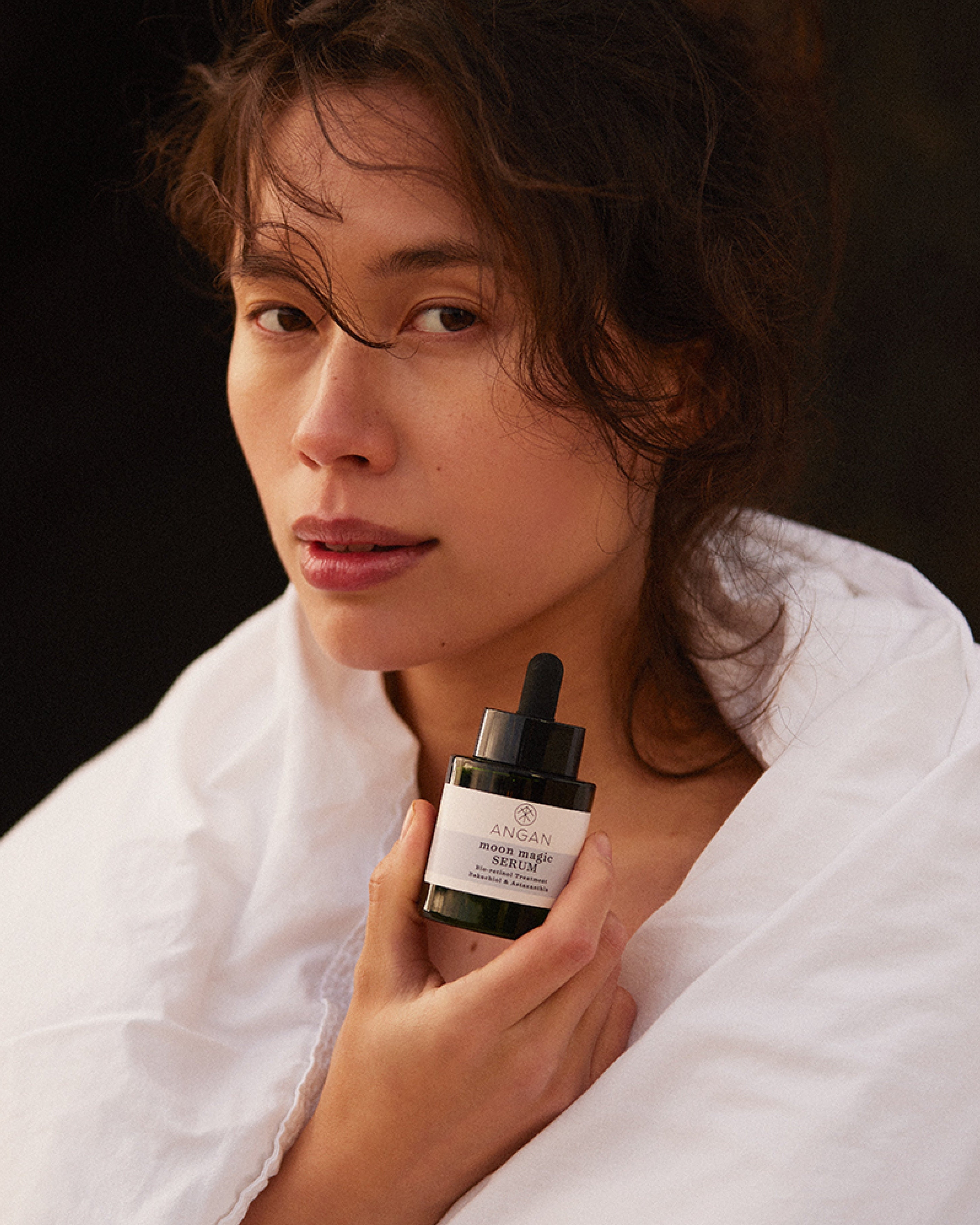 ANGAN Moon Magic Serum — model using serum in evening ritual